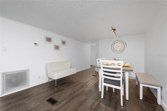 dining space featuring dark hardwood / wood-style floors and a textured ceiling