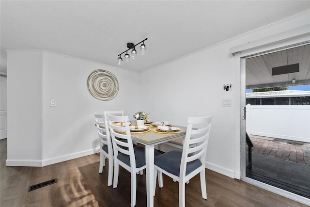 dining area with dark hardwood / wood-style floors and crown molding