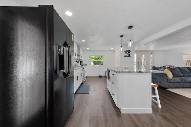 kitchen featuring stainless steel appliances, light stone counters, dark hardwood / wood-style flooring, decorative light fixtures, and white cabinets