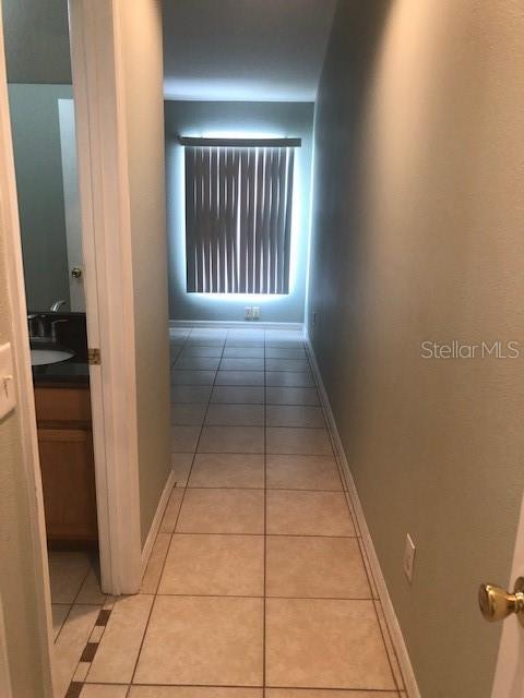 hall featuring sink and light tile patterned flooring