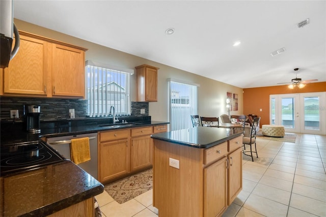 kitchen featuring sink, decorative backsplash, light tile patterned floors, appliances with stainless steel finishes, and a kitchen island