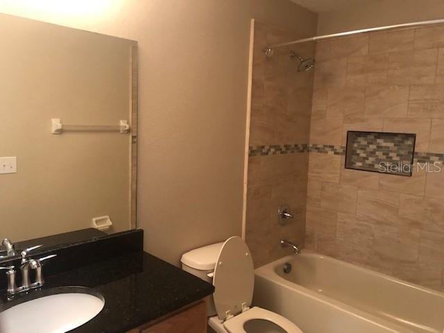 full bathroom featuring vanity, toilet, and tiled shower / bath