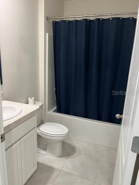 full bathroom featuring tile patterned floors, vanity, toilet, and shower / bath combo