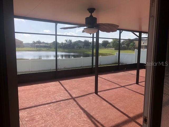 unfurnished sunroom with a water view and ceiling fan