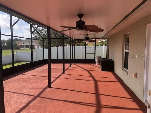 unfurnished sunroom featuring ceiling fan