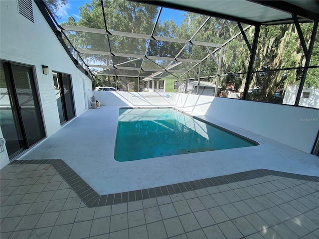 view of swimming pool with glass enclosure and a patio area