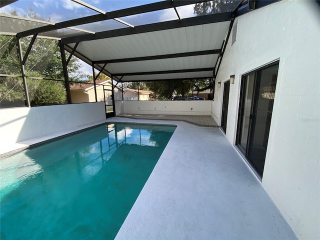 view of swimming pool featuring glass enclosure