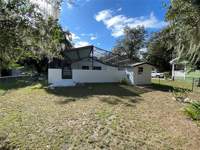 rear view of house featuring a lanai and a yard