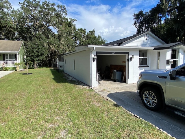 view of side of property featuring a lawn and a garage