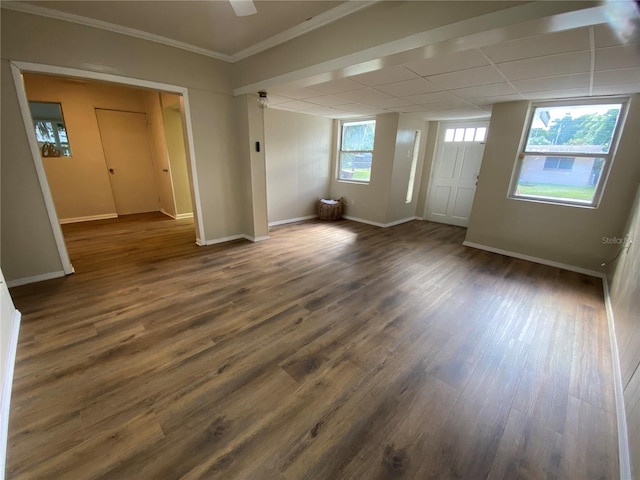 unfurnished room with a paneled ceiling, ornamental molding, and dark wood-type flooring