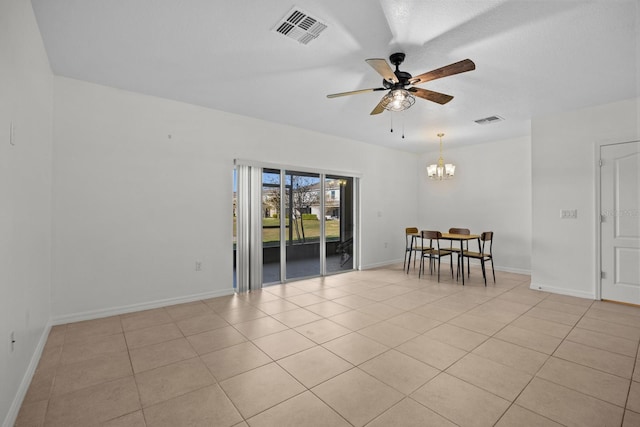 tiled spare room featuring ceiling fan with notable chandelier