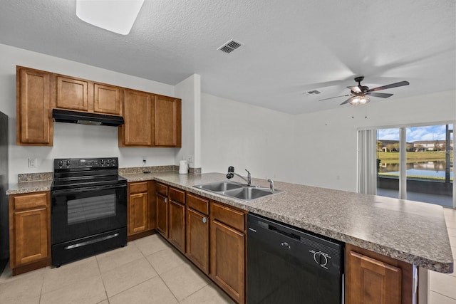 kitchen with kitchen peninsula, sink, a water view, and black appliances