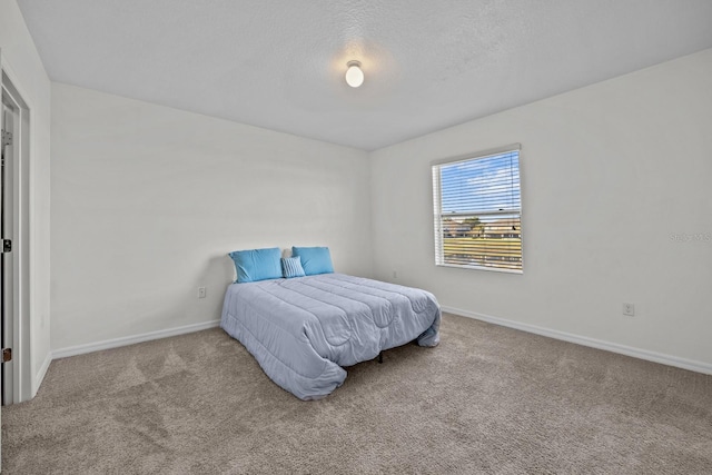 bedroom with light carpet and a textured ceiling