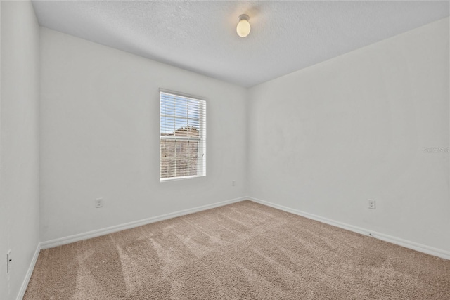 empty room with a textured ceiling and carpet floors