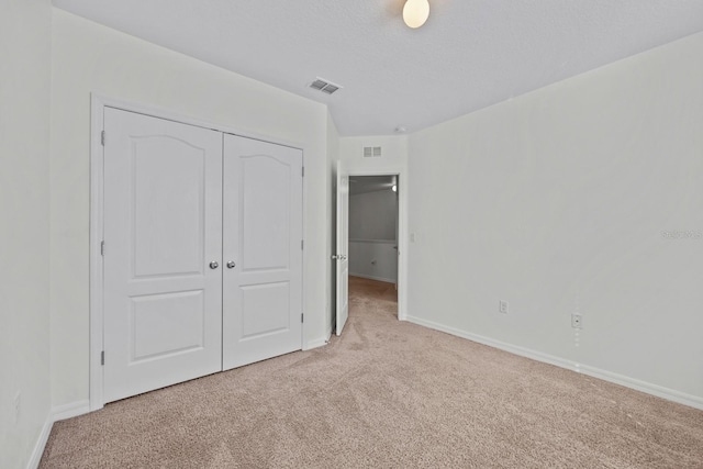 unfurnished bedroom featuring light colored carpet and a closet