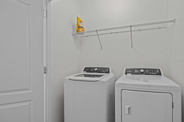 clothes washing area with washer and clothes dryer