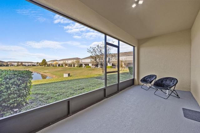 sunroom featuring a water view