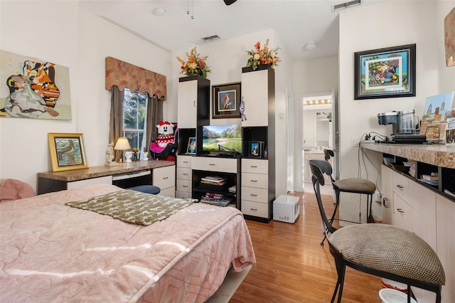 bedroom with connected bathroom and light wood-type flooring