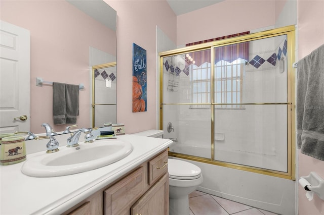 full bathroom with tile patterned flooring, vanity, enclosed tub / shower combo, and toilet