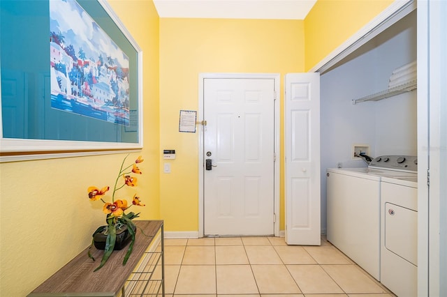 laundry area with washer and dryer and light tile patterned floors