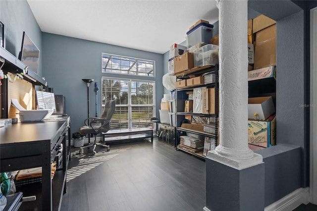 home office with dark hardwood / wood-style floors and ornate columns