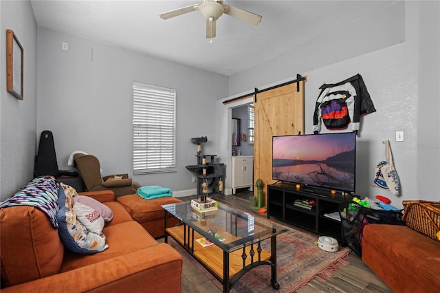 living room featuring hardwood / wood-style floors, a barn door, and ceiling fan