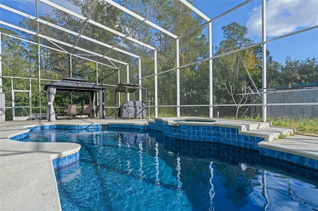 view of pool with a gazebo, glass enclosure, and an in ground hot tub