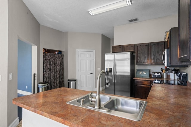 kitchen with dark brown cabinetry, sink, black range oven, stainless steel refrigerator with ice dispenser, and a textured ceiling