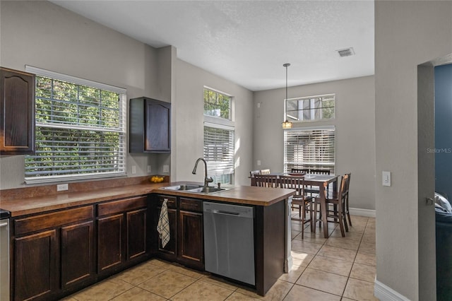 kitchen featuring kitchen peninsula, stainless steel dishwasher, sink, pendant lighting, and light tile patterned floors