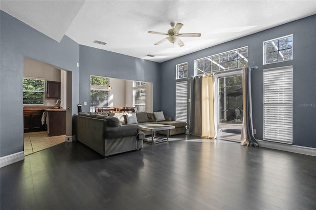 living room featuring ceiling fan, sink, a textured ceiling, and hardwood / wood-style flooring