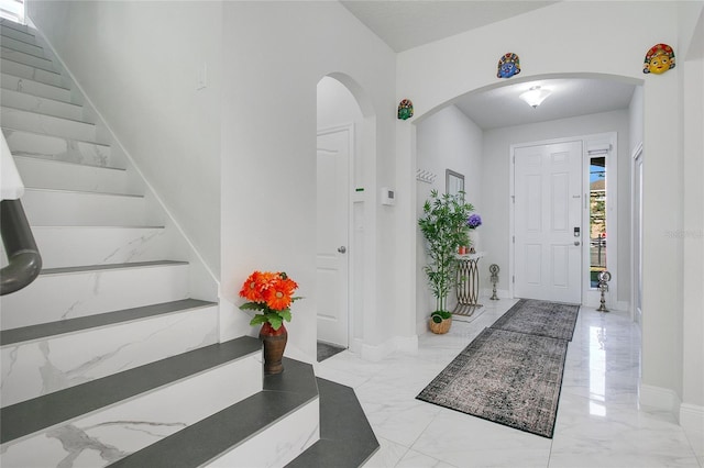 2811 Sonata Ct, Saint Cloud, FL 34772 - foyer entrance with light marble finish floors, arched walkways, stairs, and baseboards