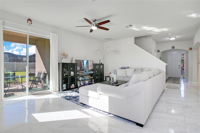 2811 Sonata Ct, Saint Cloud, FL 34772 - living area featuring arched walkways, light marble finish floors, and a ceiling fan