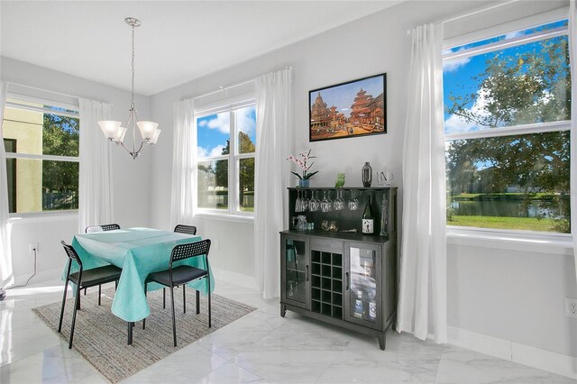 2811 Sonata Ct, Saint Cloud, FL 34772 - dining area with a chandelier, marble finish floors, healthy amount of natural light, and baseboards