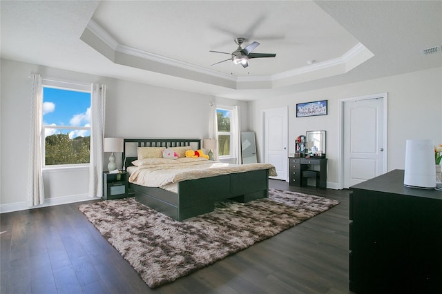 bedroom with dark hardwood / wood-style flooring, a raised ceiling, ceiling fan, and crown molding