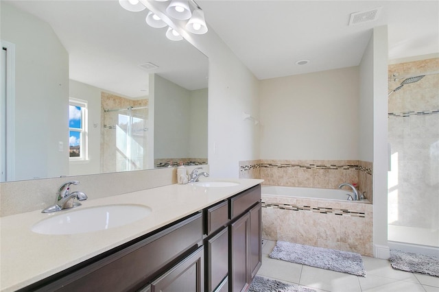 bathroom with tile patterned floors, vanity, and shower with separate bathtub