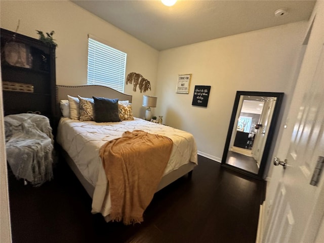 bedroom with dark hardwood / wood-style flooring