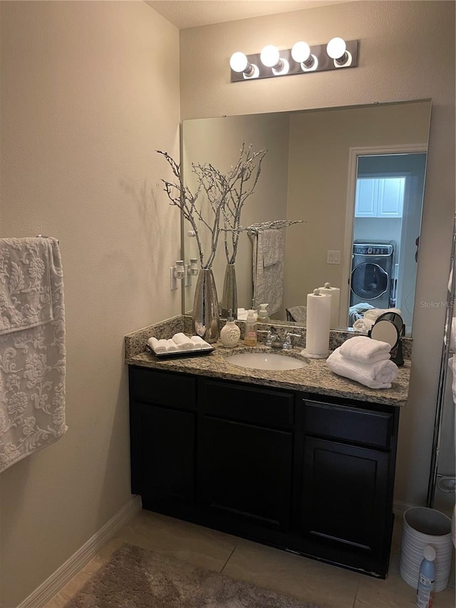 bathroom with tile patterned flooring, vanity, and washer / clothes dryer