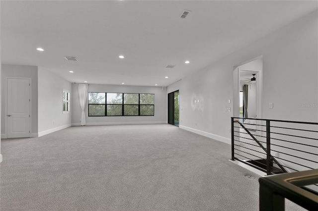 spare room with ceiling fan and light colored carpet