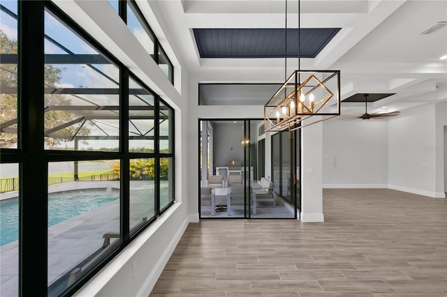 unfurnished dining area featuring hardwood / wood-style floors and ceiling fan with notable chandelier