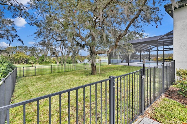 view of yard with a fenced in pool and glass enclosure