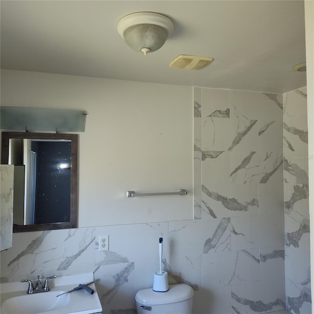 bathroom with sink and tile walls