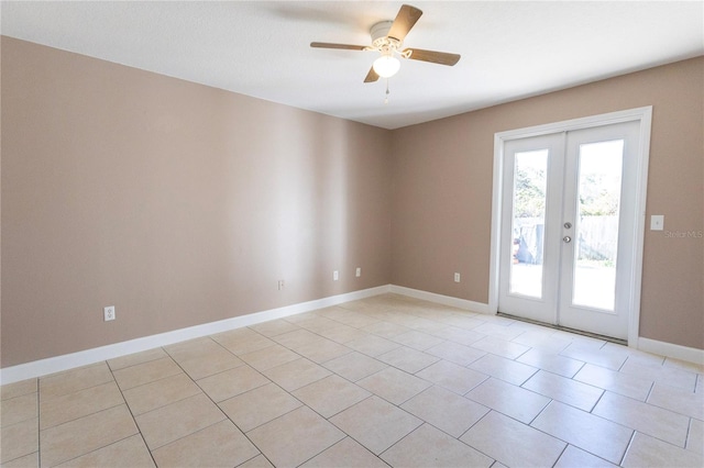 tiled spare room featuring ceiling fan and french doors