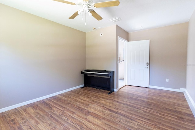 unfurnished room featuring ceiling fan and dark wood-type flooring