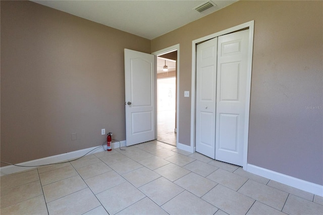 unfurnished bedroom with a closet and light tile patterned flooring