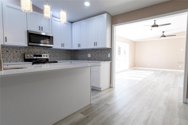 kitchen featuring backsplash, light hardwood / wood-style floors, light stone counters, white cabinetry, and stainless steel appliances