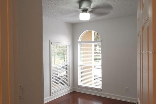 empty room with ceiling fan and dark hardwood / wood-style floors