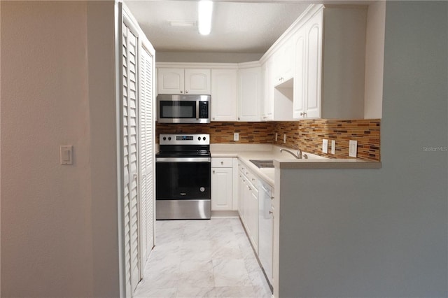 kitchen featuring decorative backsplash, sink, white cabinetry, and stainless steel appliances