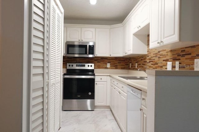 kitchen featuring sink, white cabinets, decorative backsplash, and stainless steel appliances