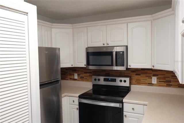 kitchen with white cabinets, backsplash, appliances with stainless steel finishes, and a textured ceiling