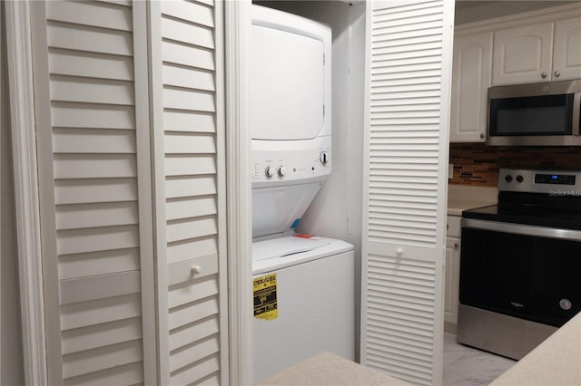 clothes washing area featuring stacked washing maching and dryer